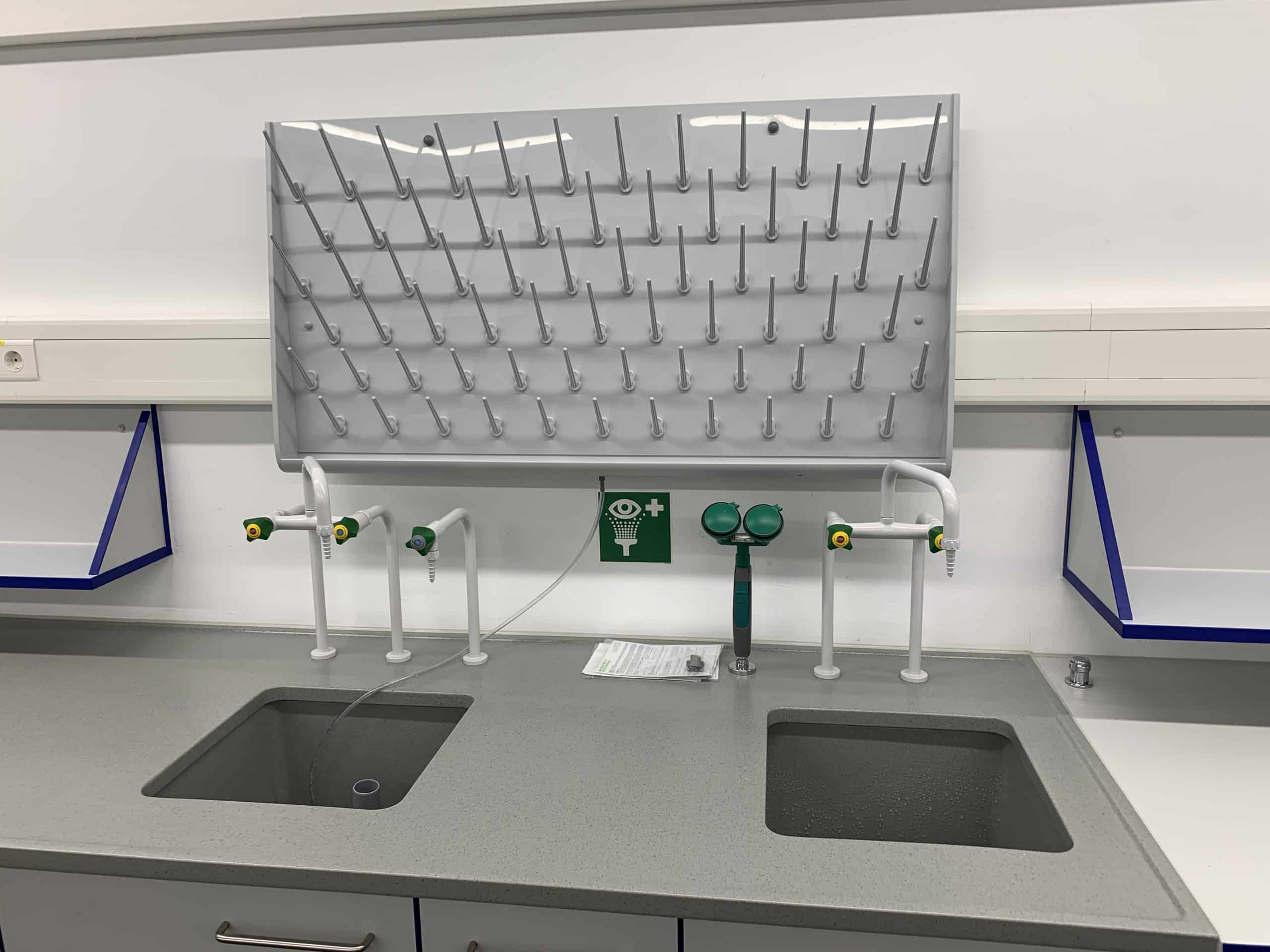 Zwei Laborspülen aus Edelstahl mit Haken zum Aufhängen von Utensilien in einem Labor